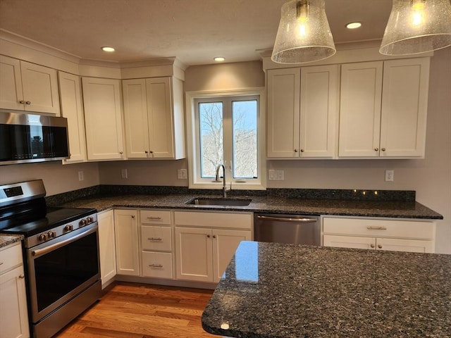 53 Kelly Ln, Lynn, MA 01904 - kitchen with a sink, light wood-style floors, dark stone counters, stainless steel appliances, and white cabinetry