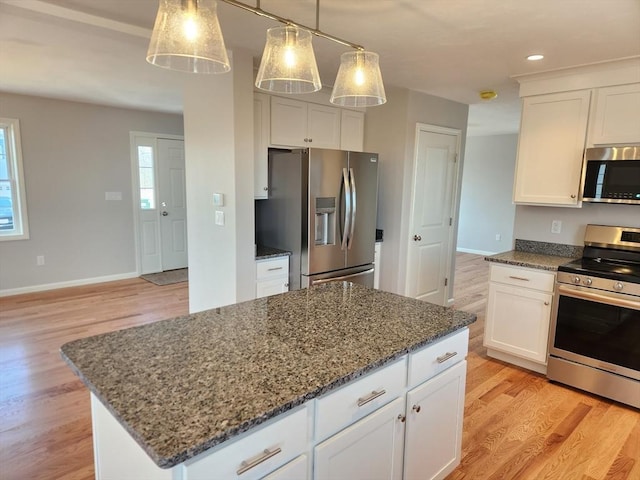 53 Kelly Ln, Lynn, MA 01904 - kitchen with dark stone counters, light wood finished floors, white cabinetry, and stainless steel appliances