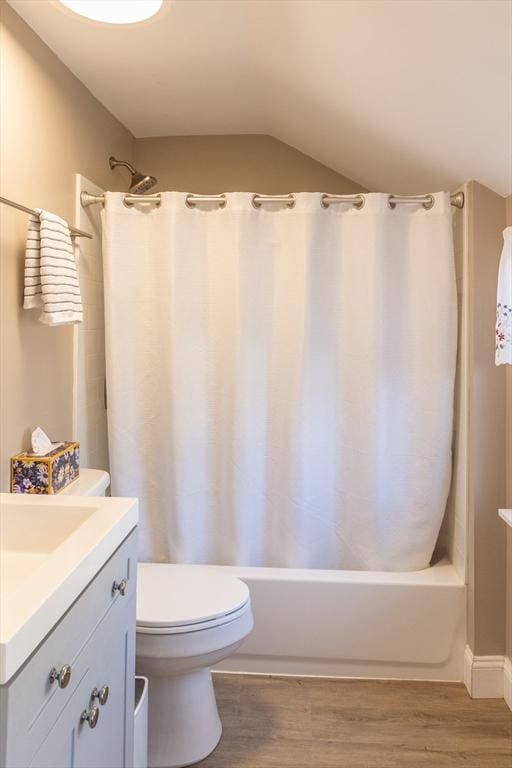 bathroom with toilet, wood finished floors, vanity, and shower / bathtub combination with curtain