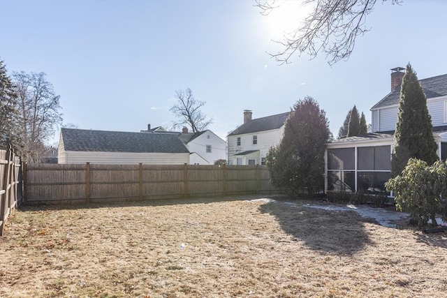 view of yard with a fenced backyard and a sunroom