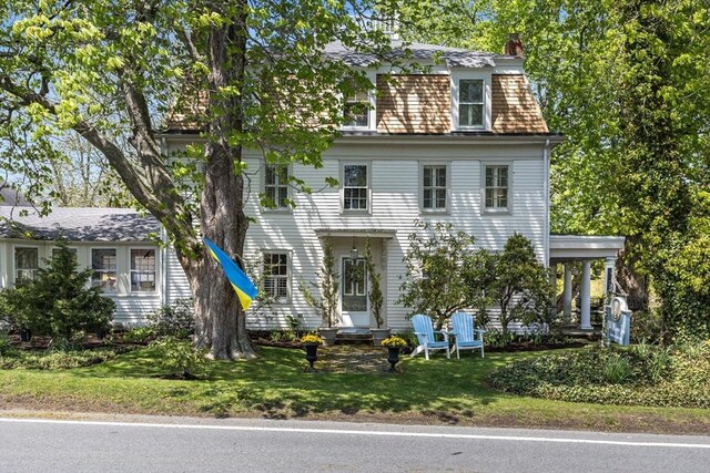 view of front of home featuring a chimney and a front yard