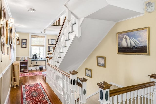 hall with wood finished floors and stairway