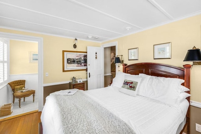 bedroom with hardwood / wood-style flooring and crown molding