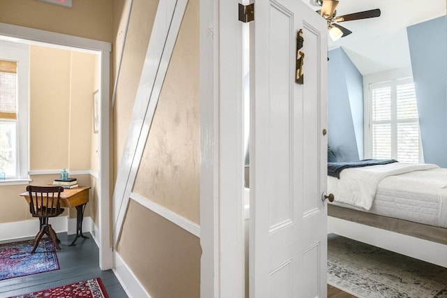 bedroom with multiple windows, baseboards, and wood finished floors