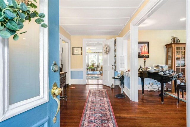 entryway with dark wood-style floors and baseboards