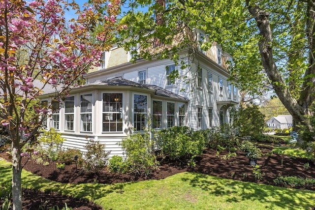 view of home's exterior with a yard and a sunroom
