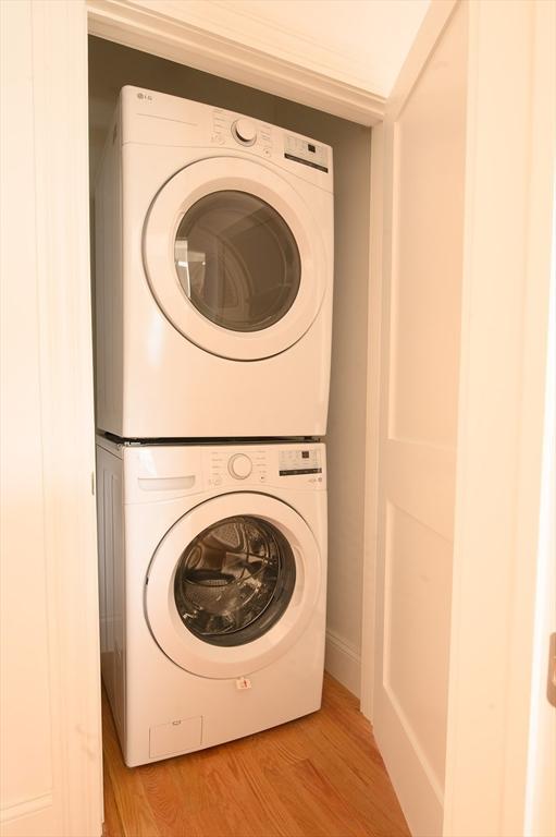 8 Brookside Ave Unit 2, Boston, MA 02130 - laundry room featuring stacked washer / drying machine and light wood-style flooring