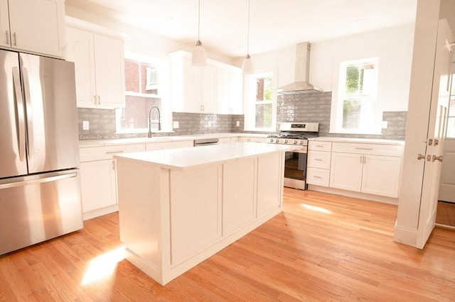 8 Brookside Ave Unit 2, Boston, MA 02130 - kitchen featuring stainless steel appliances, wall chimney exhaust hood, light wood-style flooring, and white cabinets