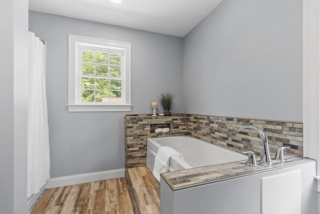 33 N Shore Rd, Westminster, MA 01473 - bathroom featuring wood finished floors, a garden tub, and decorative backsplash