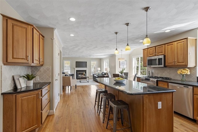 kitchen featuring plenty of natural light, a kitchen breakfast bar, a kitchen island, and stainless steel appliances