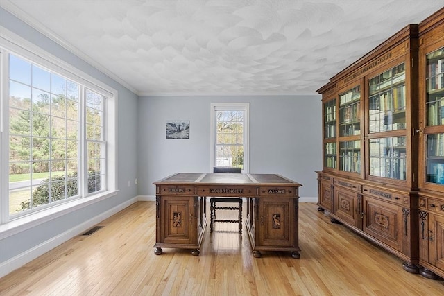 office area featuring baseboards, ornamental molding, light wood finished floors, and visible vents