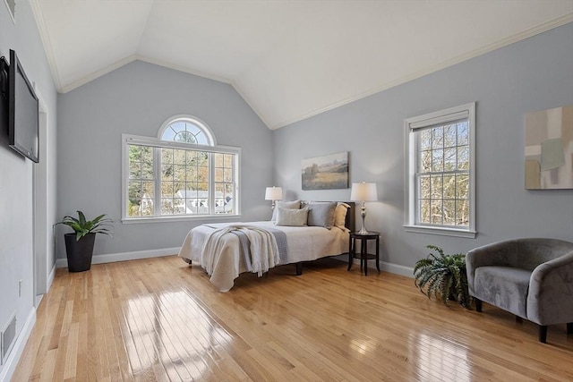 bedroom with baseboards, vaulted ceiling, and light wood-style flooring