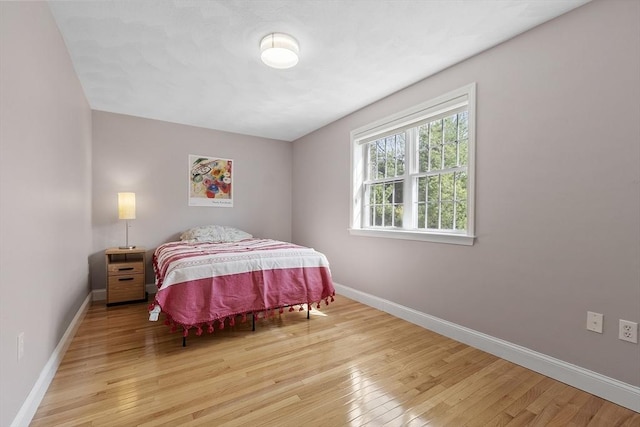 bedroom with baseboards and wood-type flooring