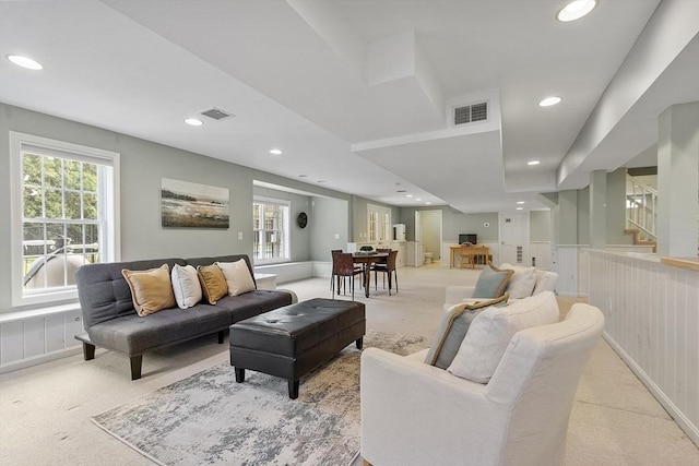 living room with a healthy amount of sunlight, light carpet, recessed lighting, and visible vents