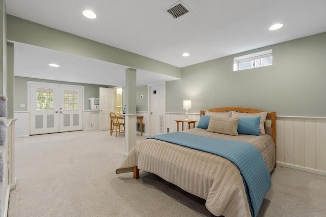 bedroom with wainscoting, visible vents, light carpet, and multiple windows
