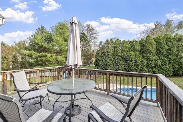 wooden deck featuring outdoor dining area and an outdoor pool