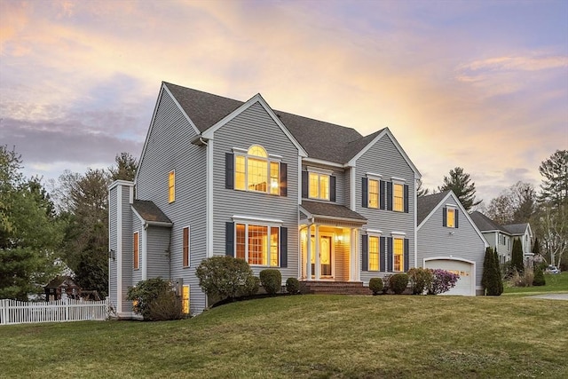 view of front of home featuring a shingled roof, fence, and a front yard