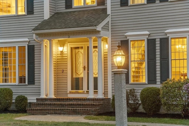doorway to property with roof with shingles