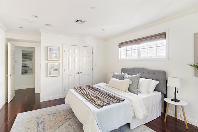 bedroom with baseboards, crown molding, visible vents, and wood finished floors