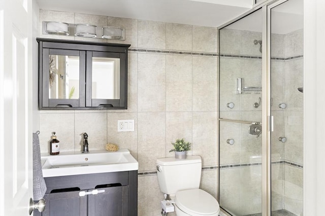 bathroom with a stall shower, tile walls, and toilet