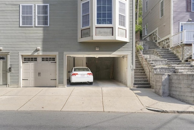 view of front of house featuring stairway, concrete driveway, and an attached garage