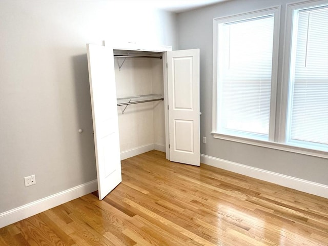 unfurnished bedroom with light wood-type flooring and a closet