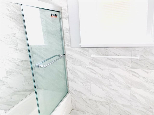 bathroom featuring bath / shower combo with glass door