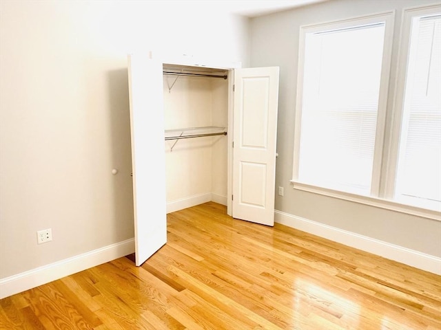 unfurnished bedroom featuring hardwood / wood-style floors and a closet