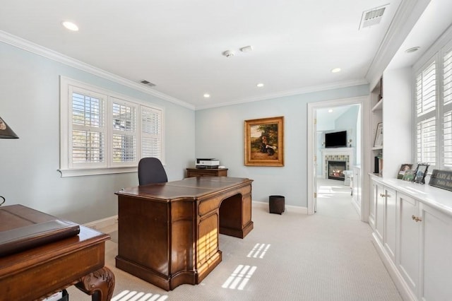 office featuring visible vents, a lit fireplace, and ornamental molding