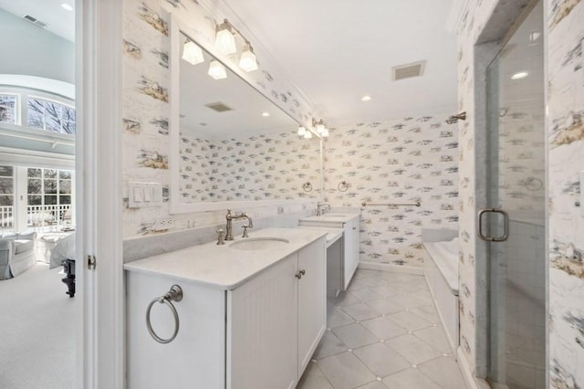 full bathroom featuring wallpapered walls, two vanities, visible vents, and a sink