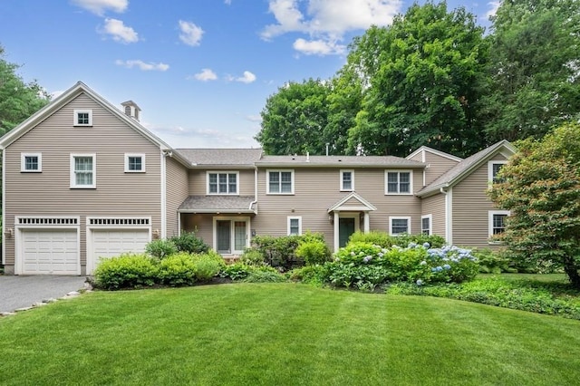 view of front of property with aphalt driveway, a garage, and a front lawn