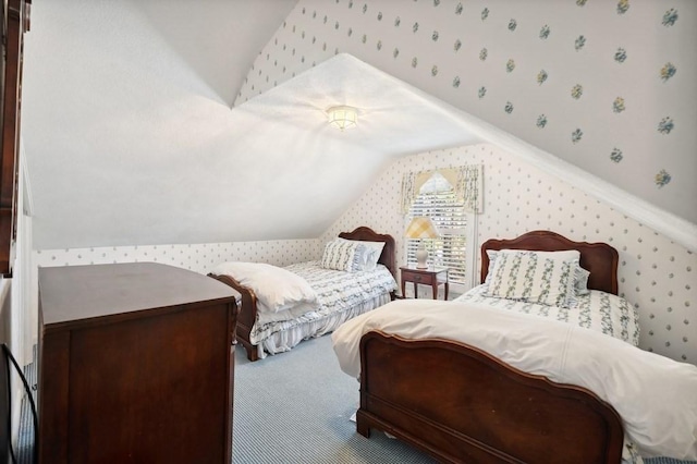 bedroom with wallpapered walls, vaulted ceiling, and carpet floors