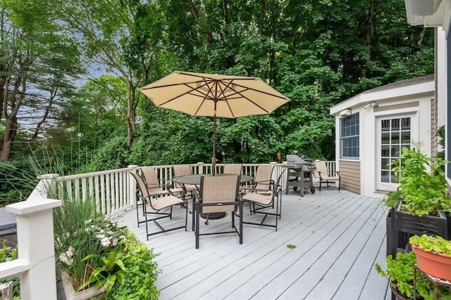 wooden terrace featuring outdoor dining area and a grill