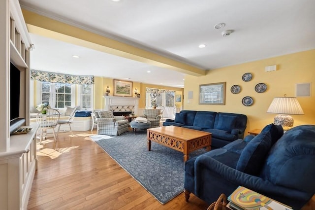 living area with beam ceiling, recessed lighting, light wood-style flooring, and a premium fireplace