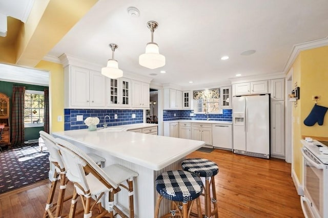 kitchen with white appliances, a breakfast bar, and ornamental molding