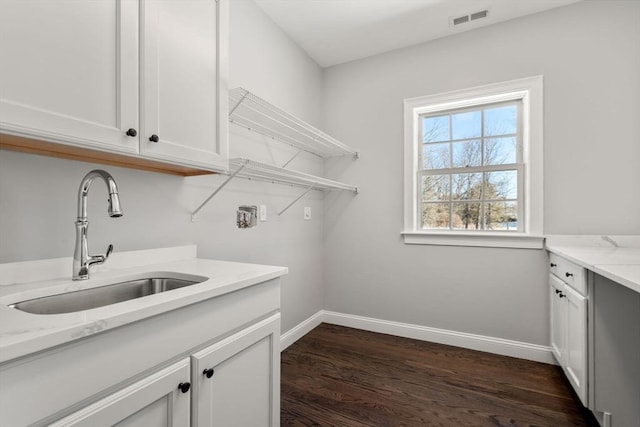 laundry room featuring cabinets, sink, washer hookup, and dark hardwood / wood-style floors