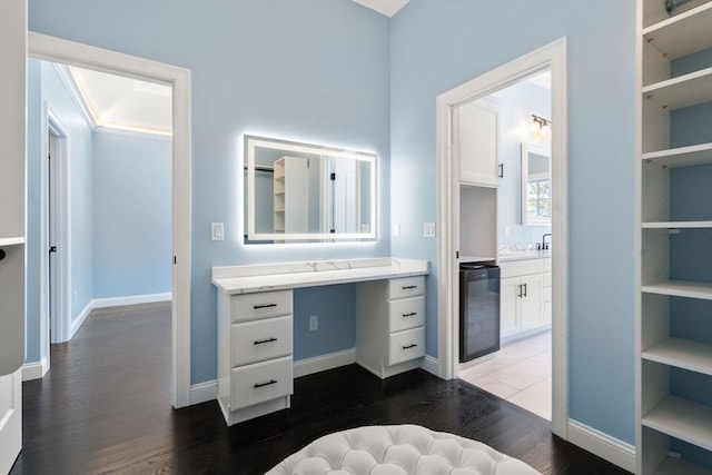 bathroom with vanity, hardwood / wood-style floors, wine cooler, and built in shelves