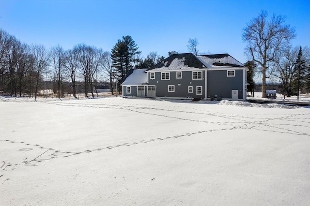 view of snow covered rear of property