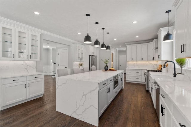 kitchen featuring decorative light fixtures, a kitchen island, and white cabinets