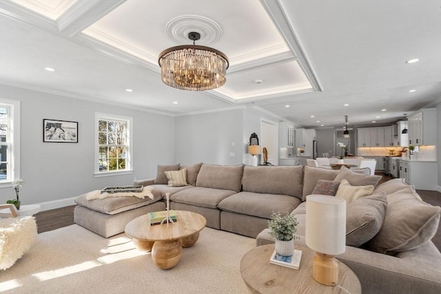 living room featuring an inviting chandelier, ornamental molding, and light hardwood / wood-style floors