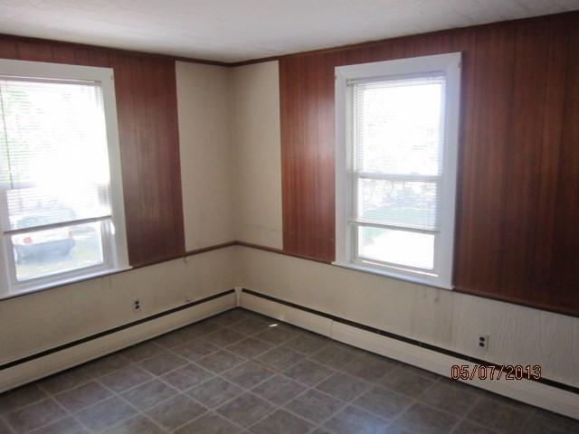 16 Chestnut, Wakefield, MA 01880 - unfurnished room with plenty of natural light, wood walls, and baseboard heating