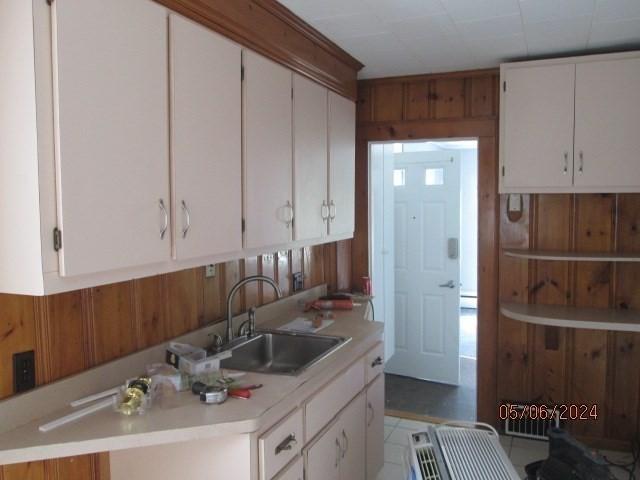16 Chestnut, Wakefield, MA 01880 - kitchen featuring light countertops, a sink, white cabinets, and wooden walls