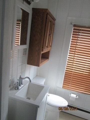 16 Chestnut, Wakefield, MA 01880 - half bath featuring vanity, toilet, a decorative wall, and a baseboard heating unit