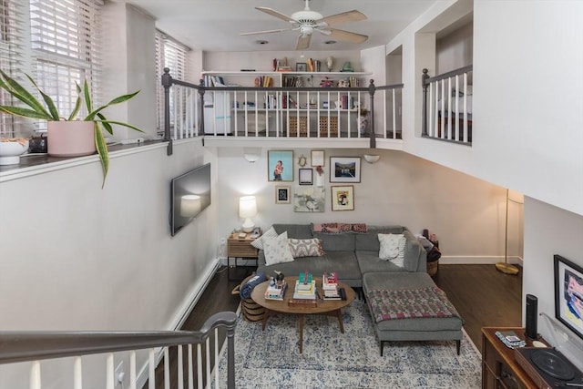 living room with wood finished floors, a ceiling fan, and baseboards