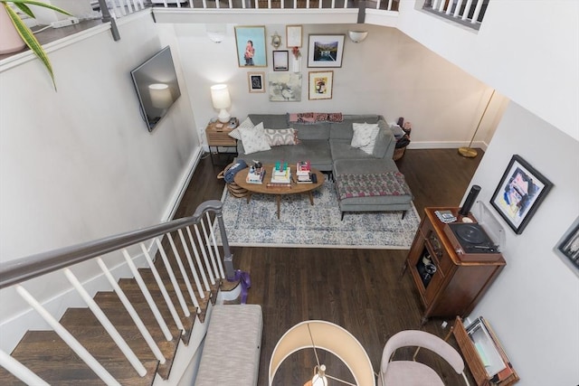 living room with wood finished floors, baseboards, and stairway