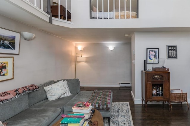 living area with wood finished floors, baseboards, and baseboard heating