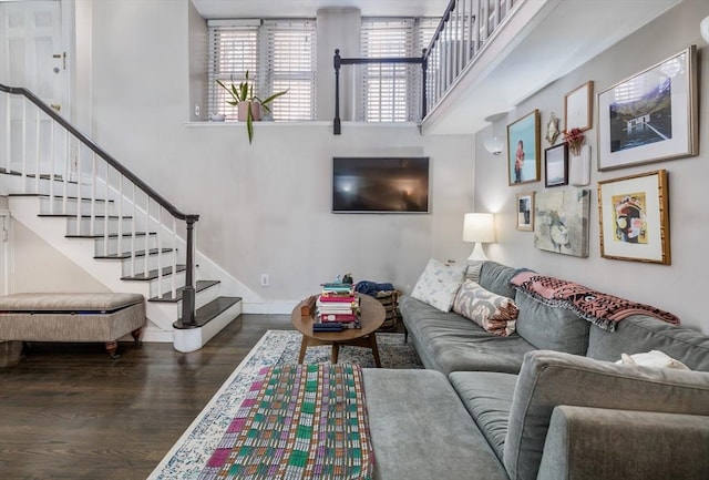 living area featuring wood finished floors, stairs, and baseboards