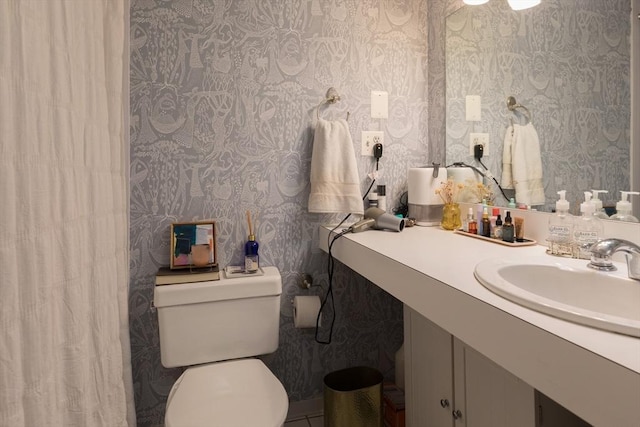 full bathroom featuring wallpapered walls, toilet, vanity, and a shower with curtain