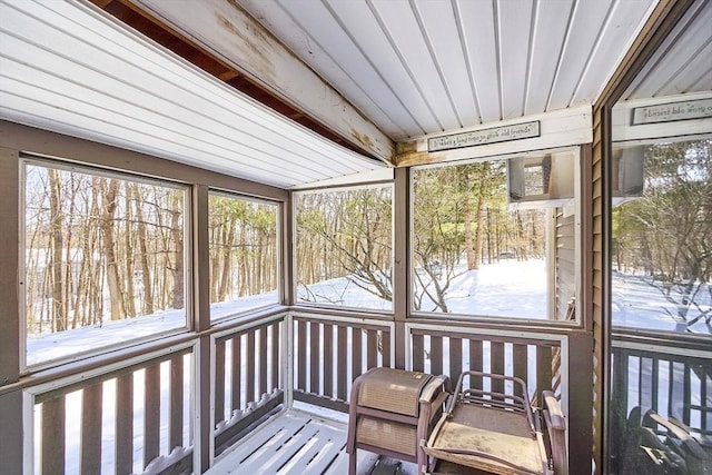 unfurnished sunroom featuring beamed ceiling