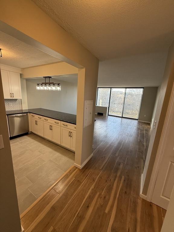 hallway featuring a textured ceiling and light hardwood / wood-style flooring